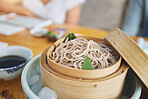 Restaurant, bamboo and closeup of a bowl of noodles for authentic Asian cuisine for diet. Food, steamer pot and zoom of Japanese ramen for a nutrition meal for dinner, lunch or supper at a diner.