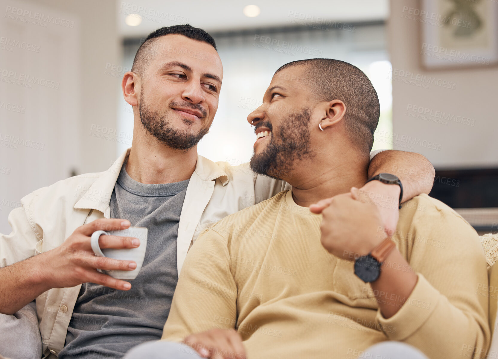 Buy stock photo Happy, love and gay couple relaxing on a sofa with a cup of coffee in the living room together. Smile, bonding and young lgbtq men with a latte sitting in the living room of their modern apartment.