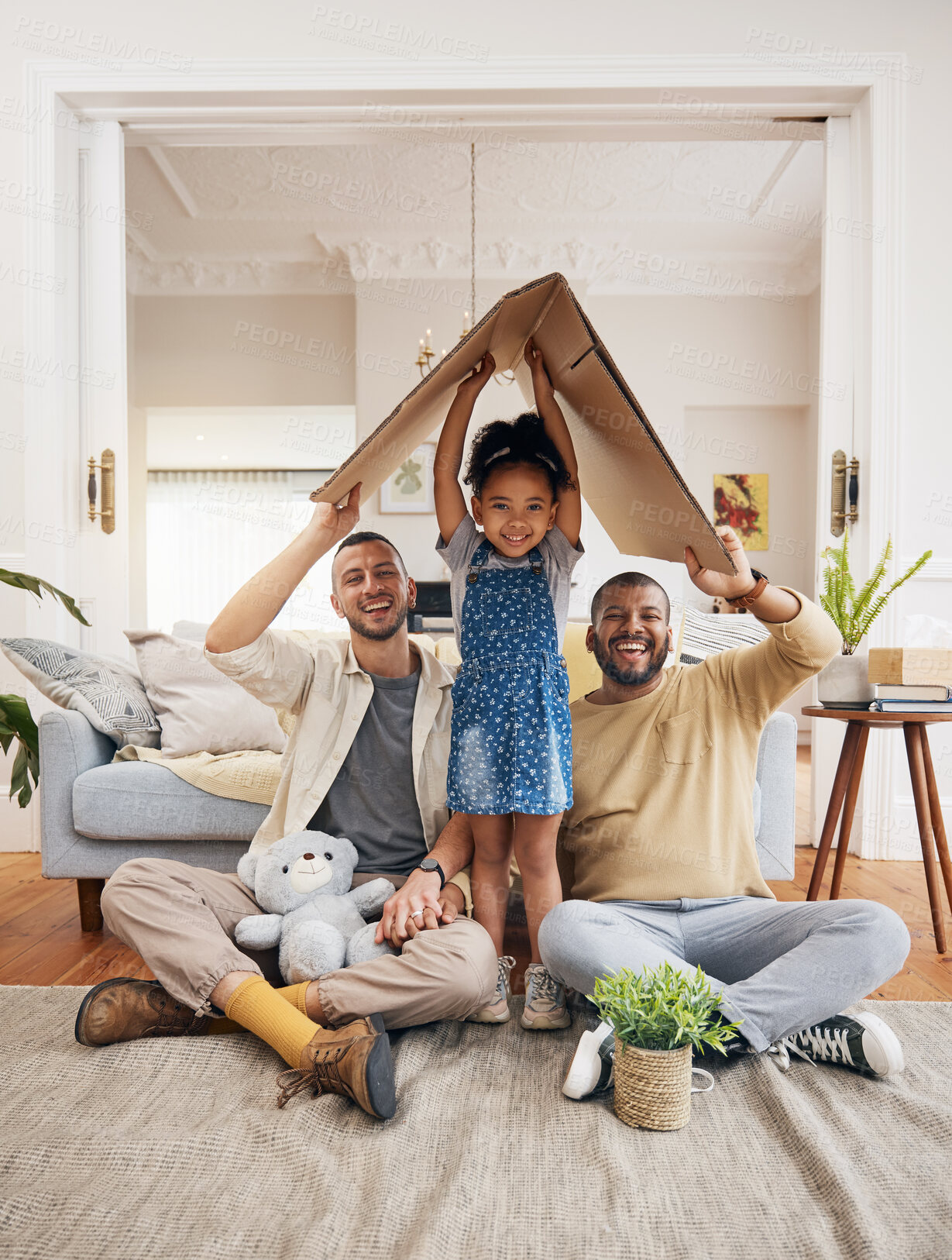 Buy stock photo Gay, happy family and a child with cardboard home or roof with love, care and safety in a lounge. Lgbtq men, adoption and parents with a foster girl kid together for new house, mortgage and insurance