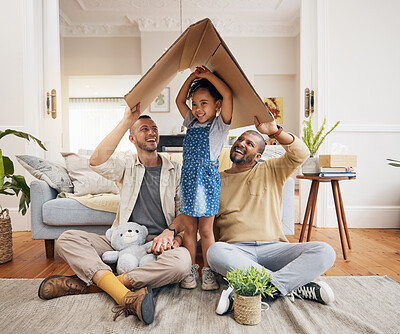 Buy stock photo Happy, gay family and a child with cardboard roof or home with love, care and safety in a lounge. Lgbtq men, adoption and parents with a foster girl kid together for new house, mortgage and insurance