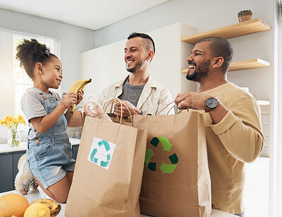 Buy stock photo Shopping, bags and happy family with groceries in home and girl with fruit and gay parents, dad and father in kitchen. Sustainable, paper bag and people with eco friendly grocery, product or fruits