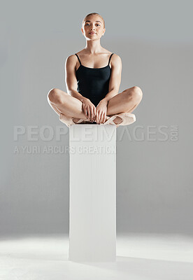 Buy stock photo Ballet, dancer and portrait of woman in studio sitting on podium with calm, posture and serious face on grey background. Dance, class or ballerina in leotard, costume and girl in pointe shoes