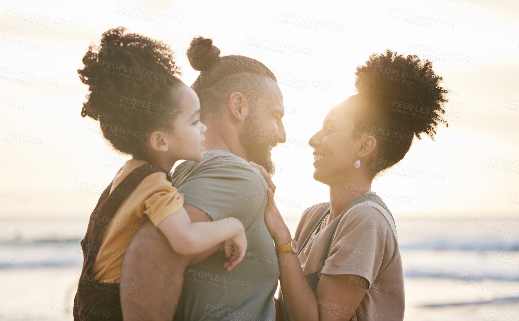 Buy stock photo Love, family and smile at beach at sunset, bonding and having fun together. Happy, mother and father of child at ocean in interracial care on summer holiday, vacation trip and travel outdoor at sea