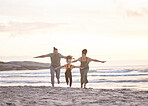 Happy, freedom and a family at the beach during sunset for flying, playing and bonding at the ocean. Smile, carefree and an interracial child, mother and father at the sea for a vacation or summer