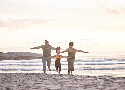 Buy stock photo Happy, freedom and a family at the beach during sunset for flying, playing and bonding at the ocean. Smile, carefree and an interracial child, mother and father at the sea for a vacation or summer