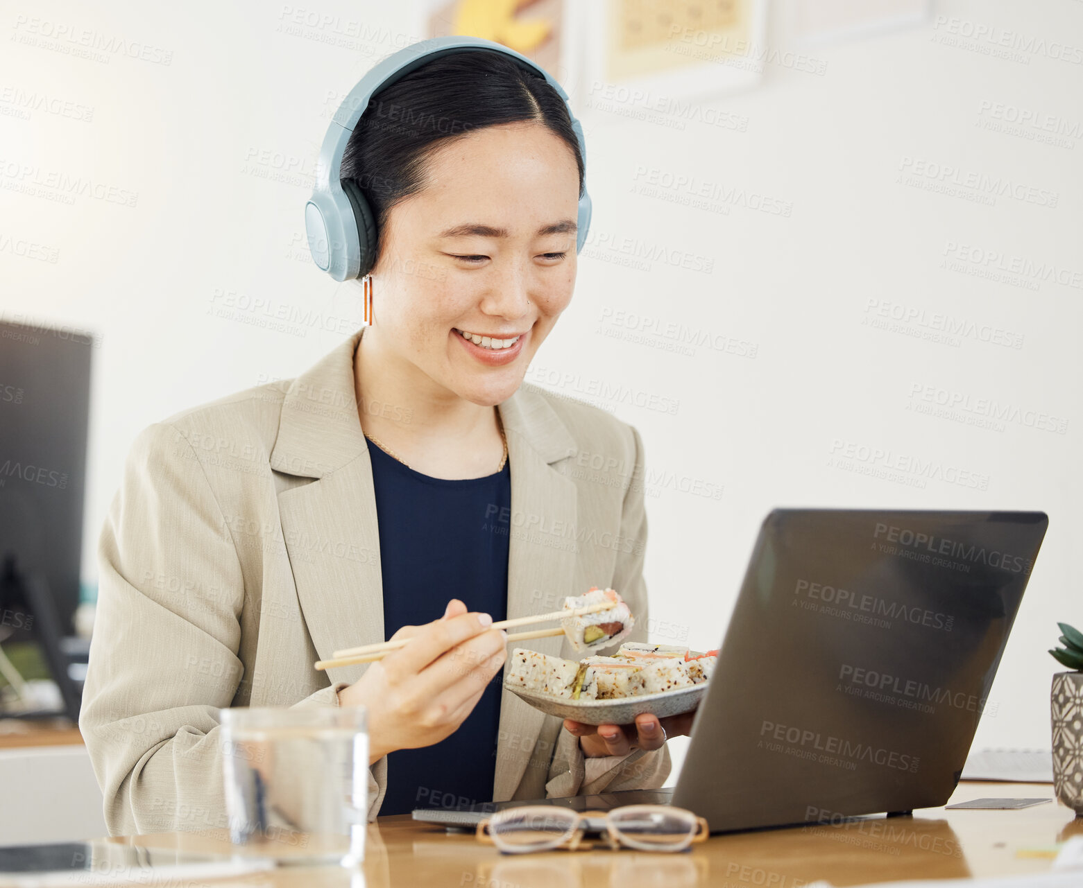 Buy stock photo Japanese business woman, laptop and sushi on lunch, video or movie in office for thinking, headphones and happy. Asian entrepreneur, eating seafood and comedy with computer, chopsticks and streaming