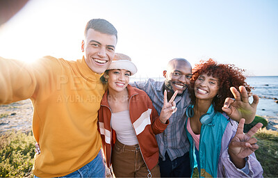 Buy stock photo Selfie, happy and portrait of friends by the beach on summer vacation, adventure or weekend trip. Smile, diversity and young people having fun and taking picture with peace sign by ocean on holiday.
