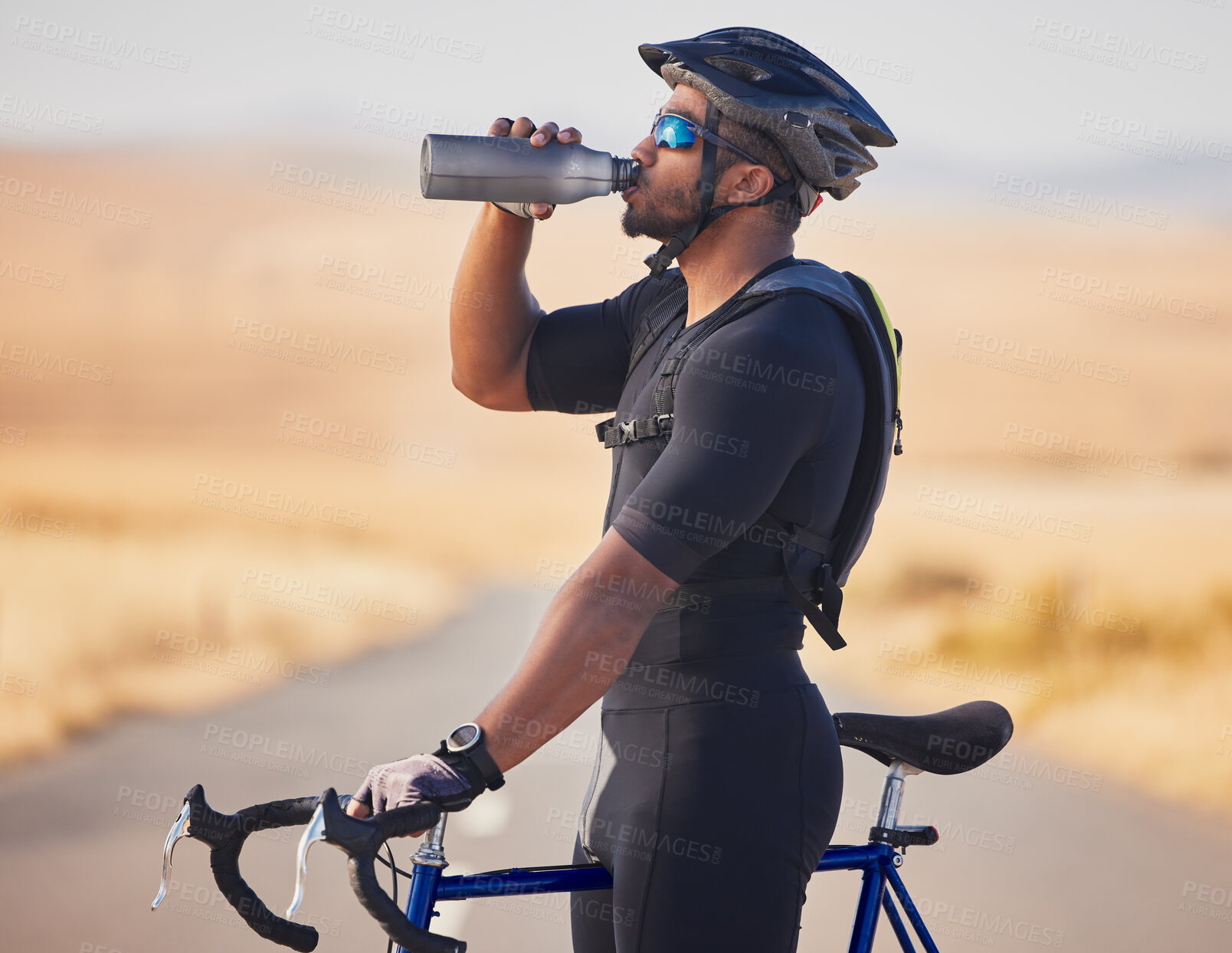 Buy stock photo Fitness, nature and man cyclist drinking water at race, marathon or competition training. Sports, workout and thirsty male athlete with hydration for health at an outdoor cardio exercise with bicycle