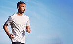 Running, man and training in summer nature and outdoor exercise with athlete in healthy workout or mockup of fitness. Male, runner and motivation in morning cardio, sports or health goals on blue sky