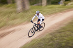 Nature, mountain bike speed and sports man travel, action and ride bicycle for cycling, fitness or exercise. Top view dirt path, fast motion blur and extreme cyclist training for race on forest land