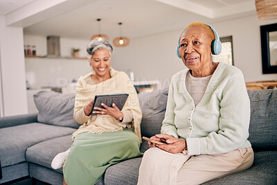 Buy stock photo Headphones, relax and senior women on sofa in home listen to music, audio and radio with friend. Retirement, technology and people in living room on tablet for streaming track, song or subscription