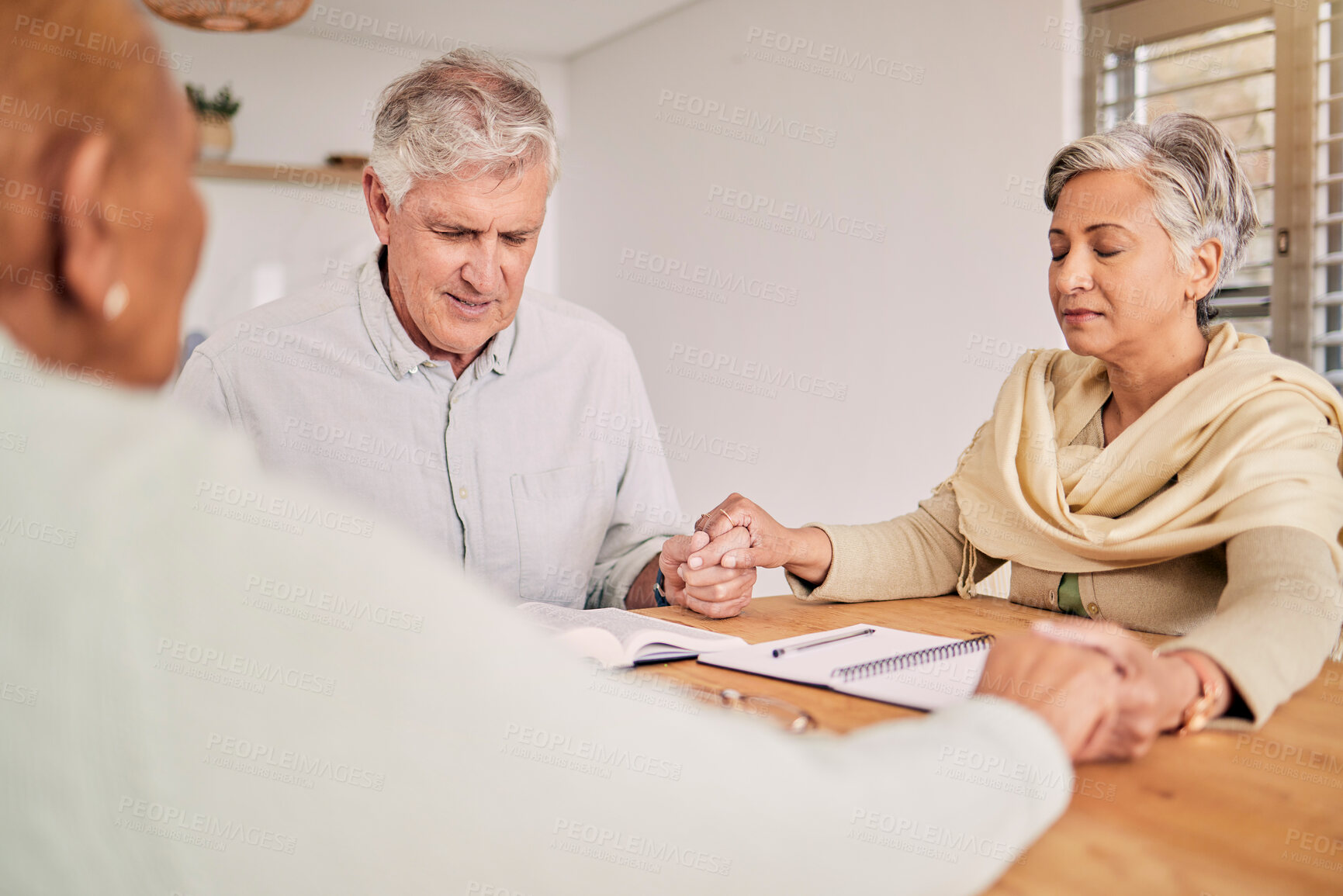 Buy stock photo Elderly friends, prayer and holding hands in home, bible study and hope in spiritual faith. Senior people, group and religion at table together, support and worship Holy Spirit, Jesus Christ and God