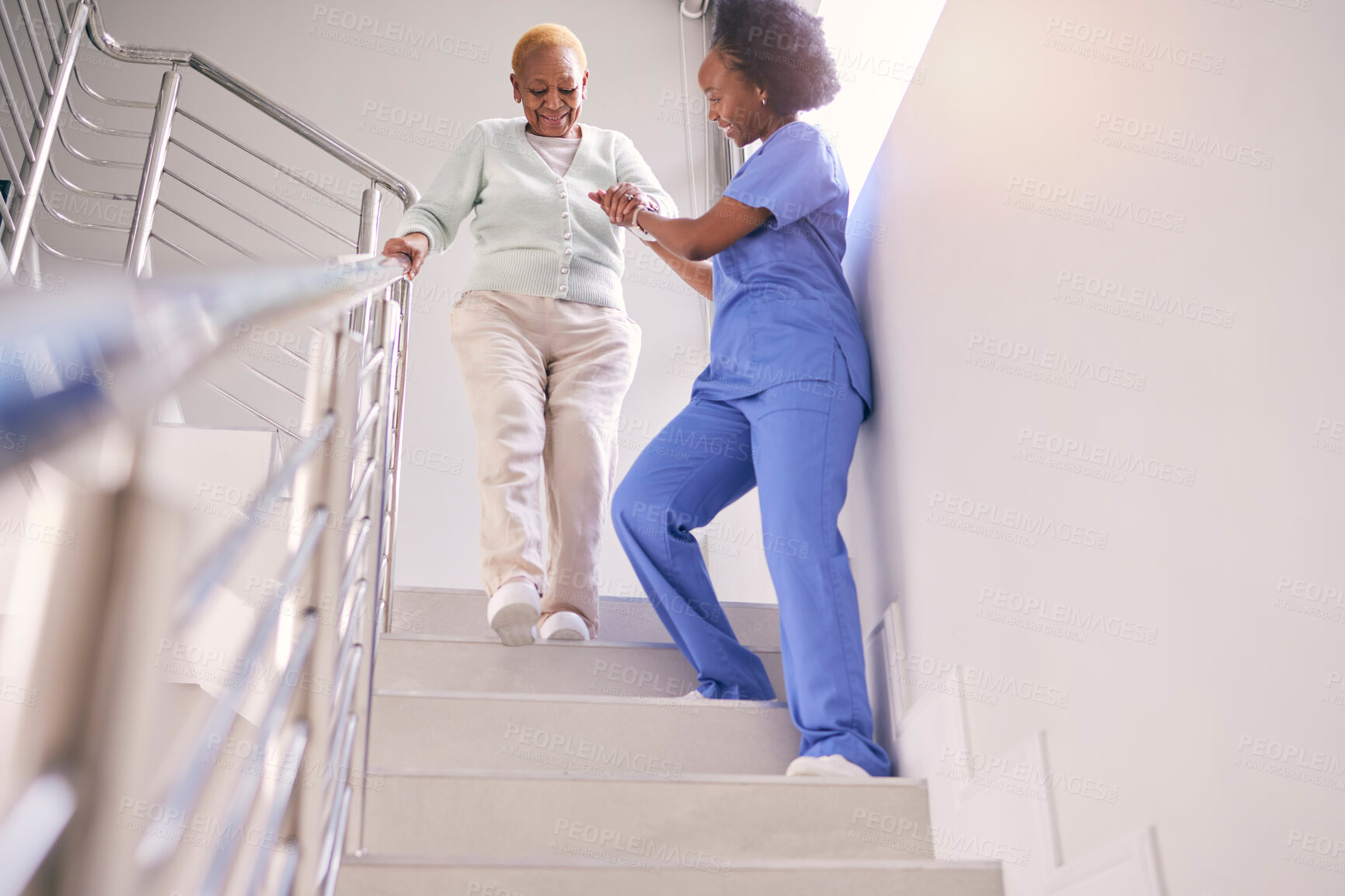 Buy stock photo Steps, nurse and help elderly woman, holding hands and assistance in home. Caregiver, stairs and senior African patient walking down, support of person with a disability and kindness in healthcare