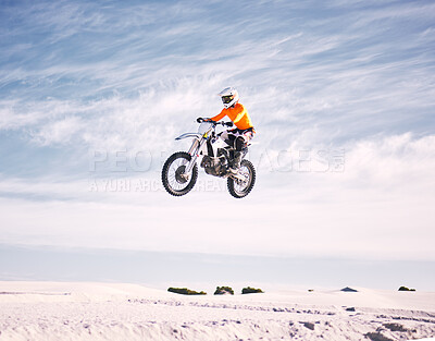 Buy stock photo Bike, speed and jump with a man on sand riding a vehicle in the desert for adventure or adrenaline. Motorcycle, training and freedom with an athlete in the sky in nature for power or competition