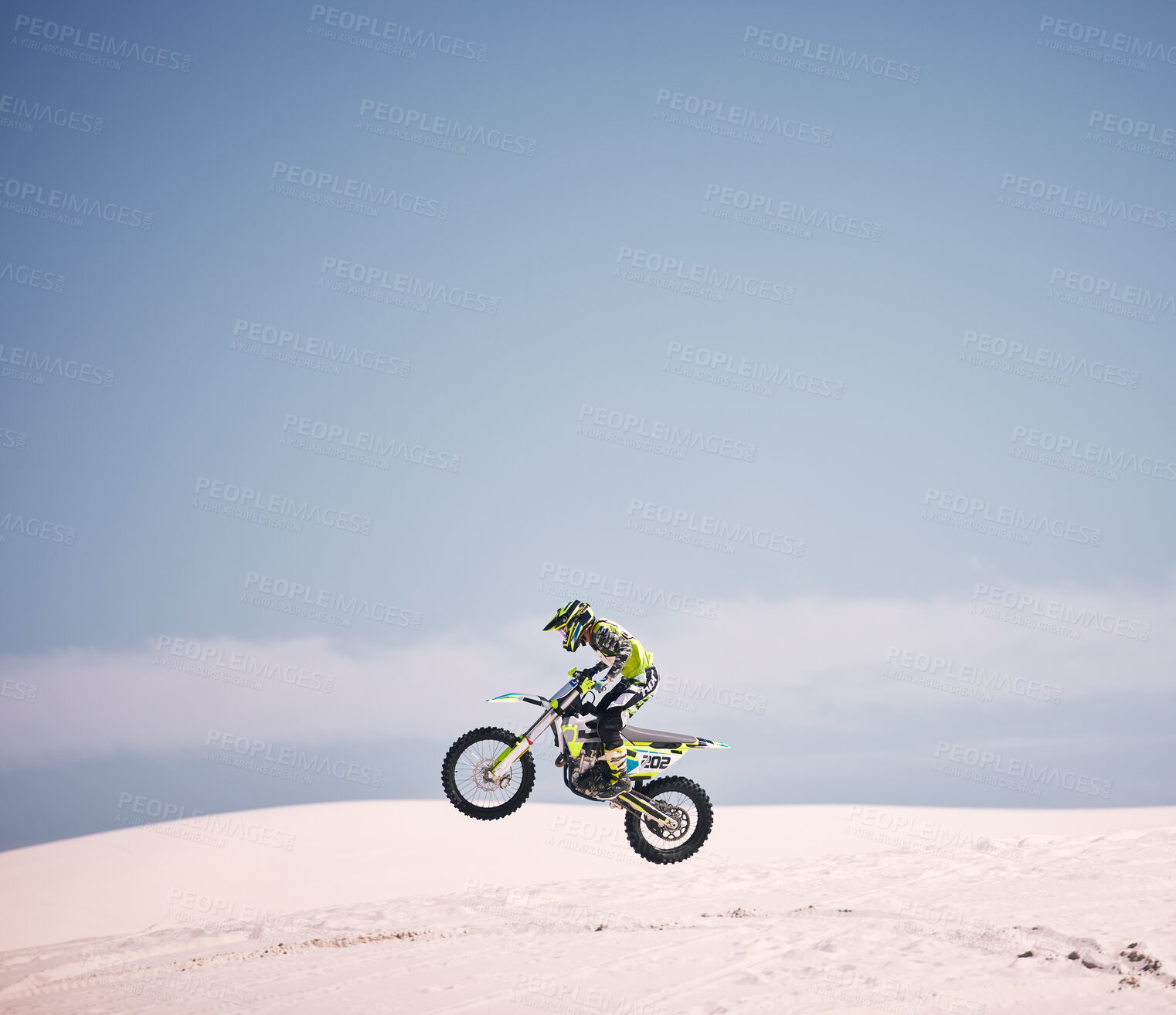 Buy stock photo Bike, sky and jump with a man on mockup riding a vehicle in the desert for adventure or adrenaline. Motorcycle, speed and space with an athlete on sand in nature for freedom, power or competition