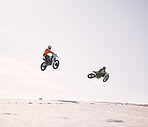 Dune, jump and men on motorbike together for practice, training and extreme sports energy in nature. Professional dirt biking challenge, friends and danger with motorcycle competition on desert hill.