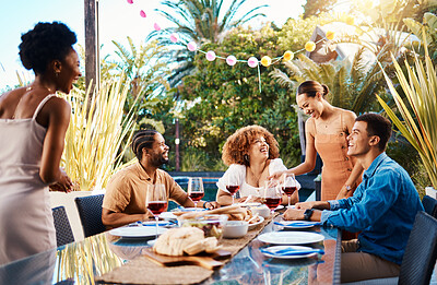 Happy people, friends and food outdoor on a table for social gathering, happiness and holiday celebration. Diversity, men and women group eating lunch at party or event with wine to relax in garden