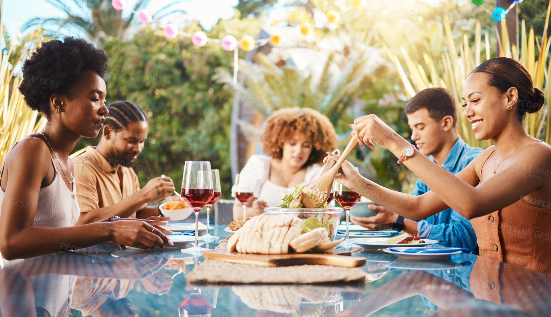 Buy stock photo Friends at lunch, party in garden and happy event with diversity, food and wine for bonding together. Outdoor dinner, men and women at table, group of people eating with drinks in backyard in summer.