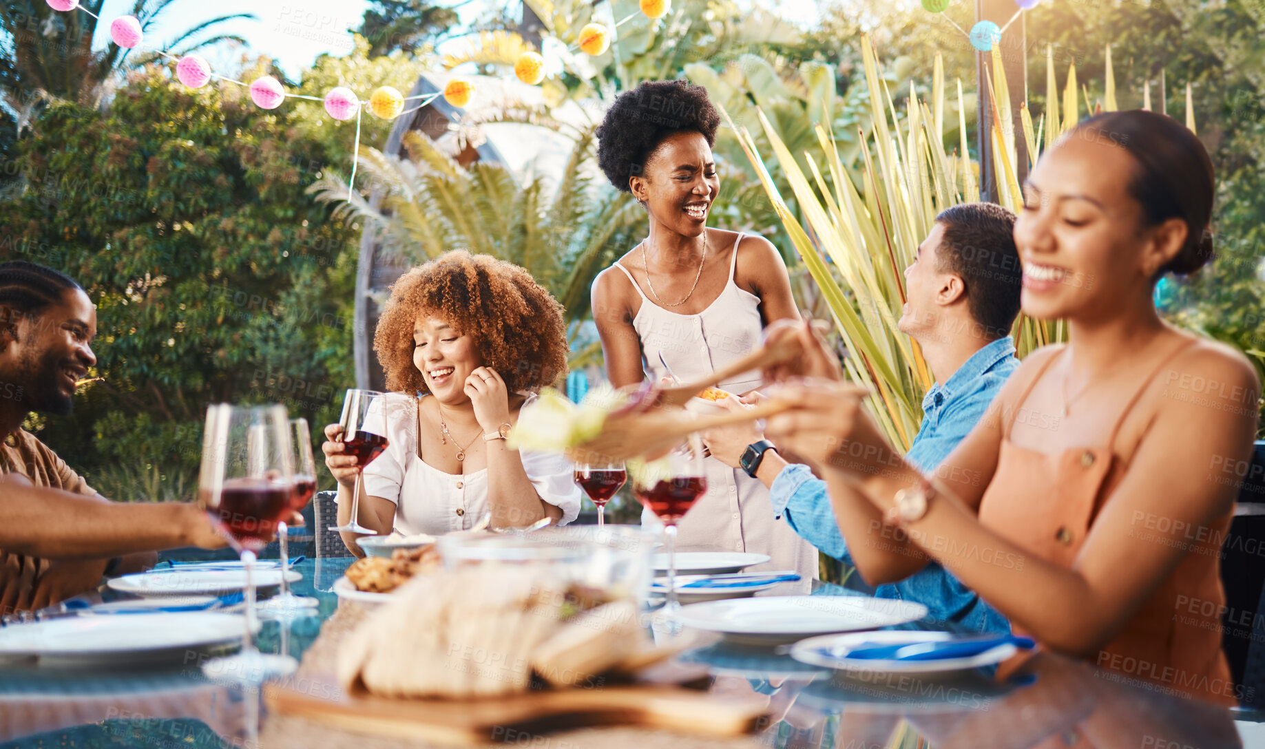 Buy stock photo Group of friends at lunch, party in garden with smile, eating and happy event with diversity. Outdoor dinner, men and women at table with food, wine and talking together in backyard with celebration.