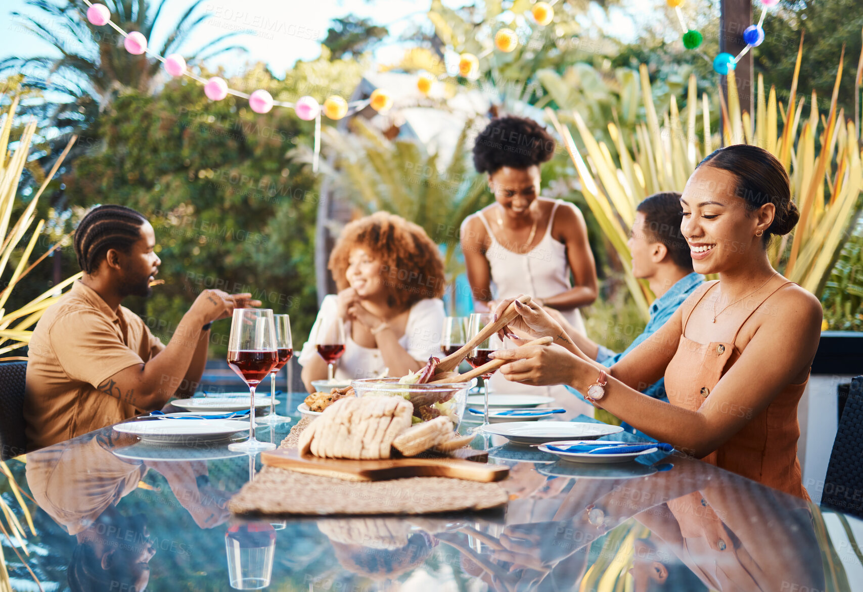 Buy stock photo Friends, food and celebration, lunch in garden and happy event with diversity, conversation and wine. Outdoor dinner, men and women at table, group of people eating with drinks in backyard in summer.