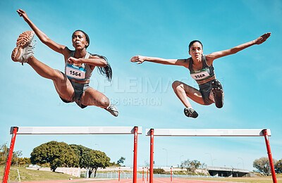 Buy stock photo Sports, hurdles and team of women on track running in a race, marathon or competition in stadium. Fitness, workout and female athletes jumping with speed and energy for outdoor training or practice.