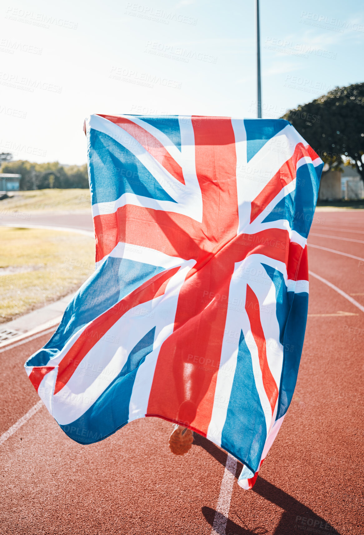 Buy stock photo British flag, athlete running and race winner in celebration, sport achievement and training exercise on track. UK banner, victory and patriotism of person to support country in success of champion