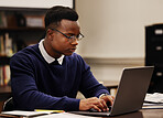 Student, learning and black man typing on a laptop in university or college campus working on assignment project. Online, studying and young person prepare for internet exam or doing research 