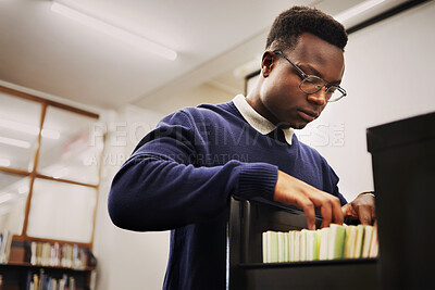 Buy stock photo School research, notes and a black man in a library for knowledge, learning or studying. University, scholarship and a young African person or student looking at books for decision or choice