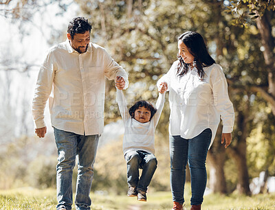 Buy stock photo Outdoor, parents and kid holding hands, love and fun with bonding, weekend break and walking. Happy family, mother and father with child, playful or adventure in a park, freedom and swing with energy