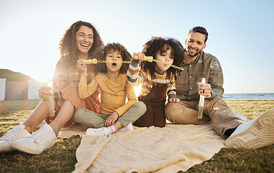 Buy stock photo Parents, children and fun bubbles at picnic at beach vacation home with smile, love and relax. Mom, dad and kids on blanket on grass with soap bubble wand, bonding ocean holiday together in summer.