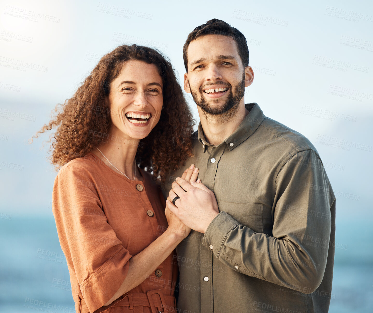 Buy stock photo Couple, portrait and smile at beach, love and excited with holding hands, care and romance on holiday. Man, woman and happy for marriage, vacation and bonding by ocean, waves and outdoor in Naples