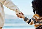 Family, holding hands and parent with a child on the beach while on summer vacation for travel together from the back. Love, children or nature with a kid and adult looking at the view of the ocean