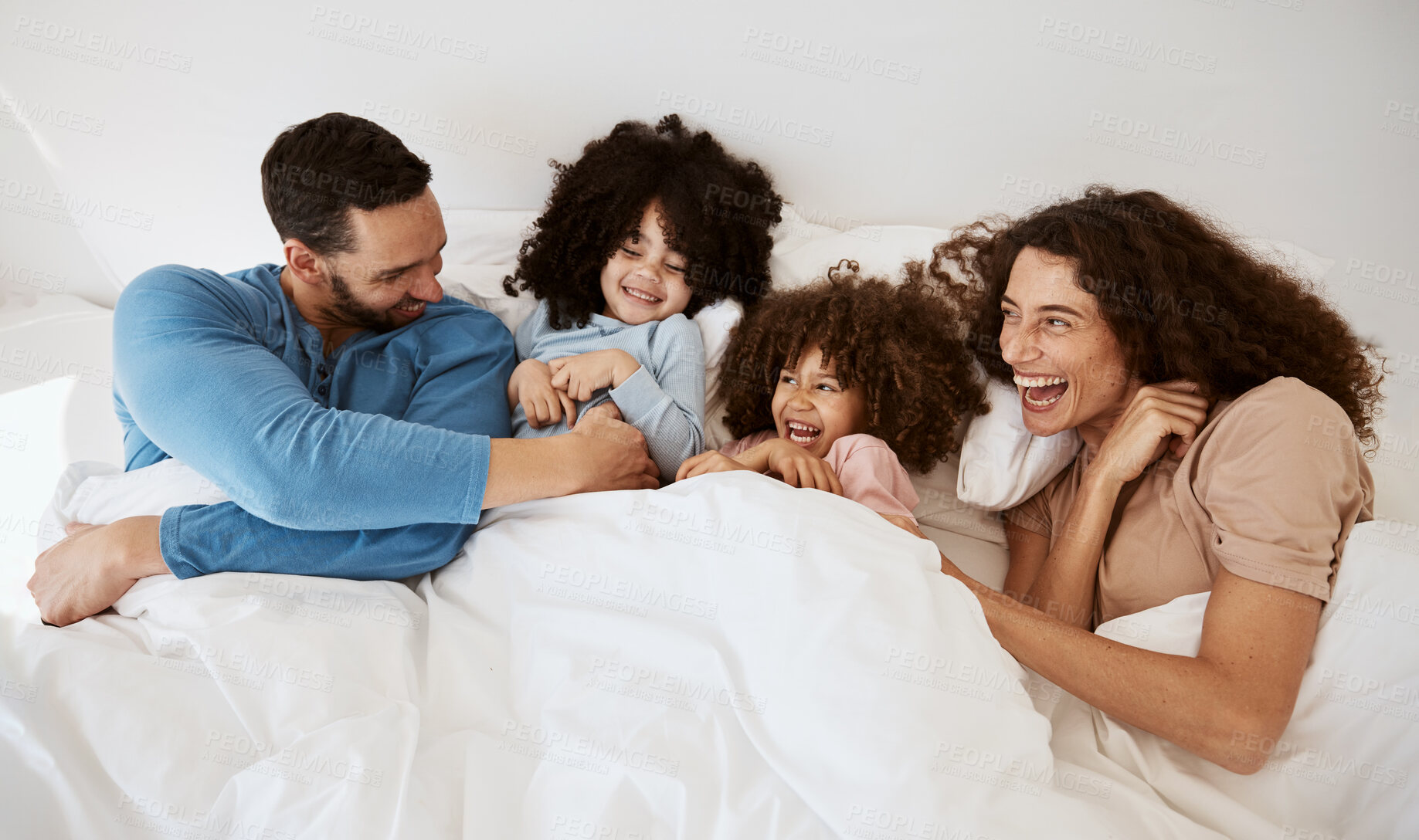 Buy stock photo Top view bedroom, children and parents laugh, relax and enjoy funny joke together, love or morning humour. Bed, comedy and happy family mother, father and interracial kids wellness, rest and comfort