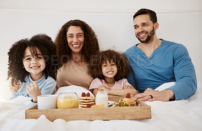 Buy stock photo Happy family, kids and portrait of breakfast in bed, eating food and enjoy quality time together in home apartment. Smile, relax and bedroom children, mom and dad with meal, orange juice and pancakes