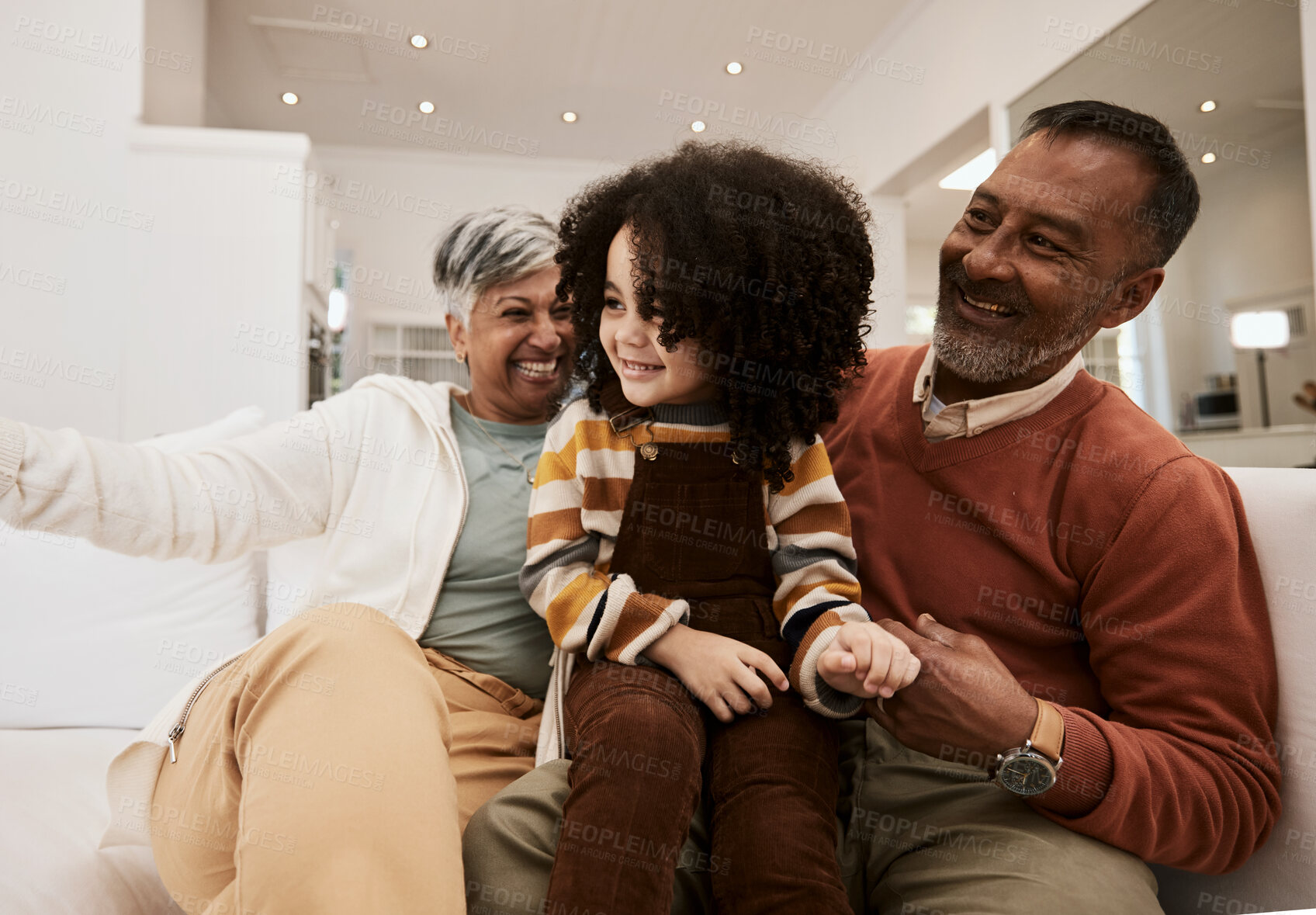 Buy stock photo Grandparents, home smile and family kid, grandma and grandfather laughing, having fun and enjoy quality time together. Living room couch, grandfather and grandmother play with child during retirement