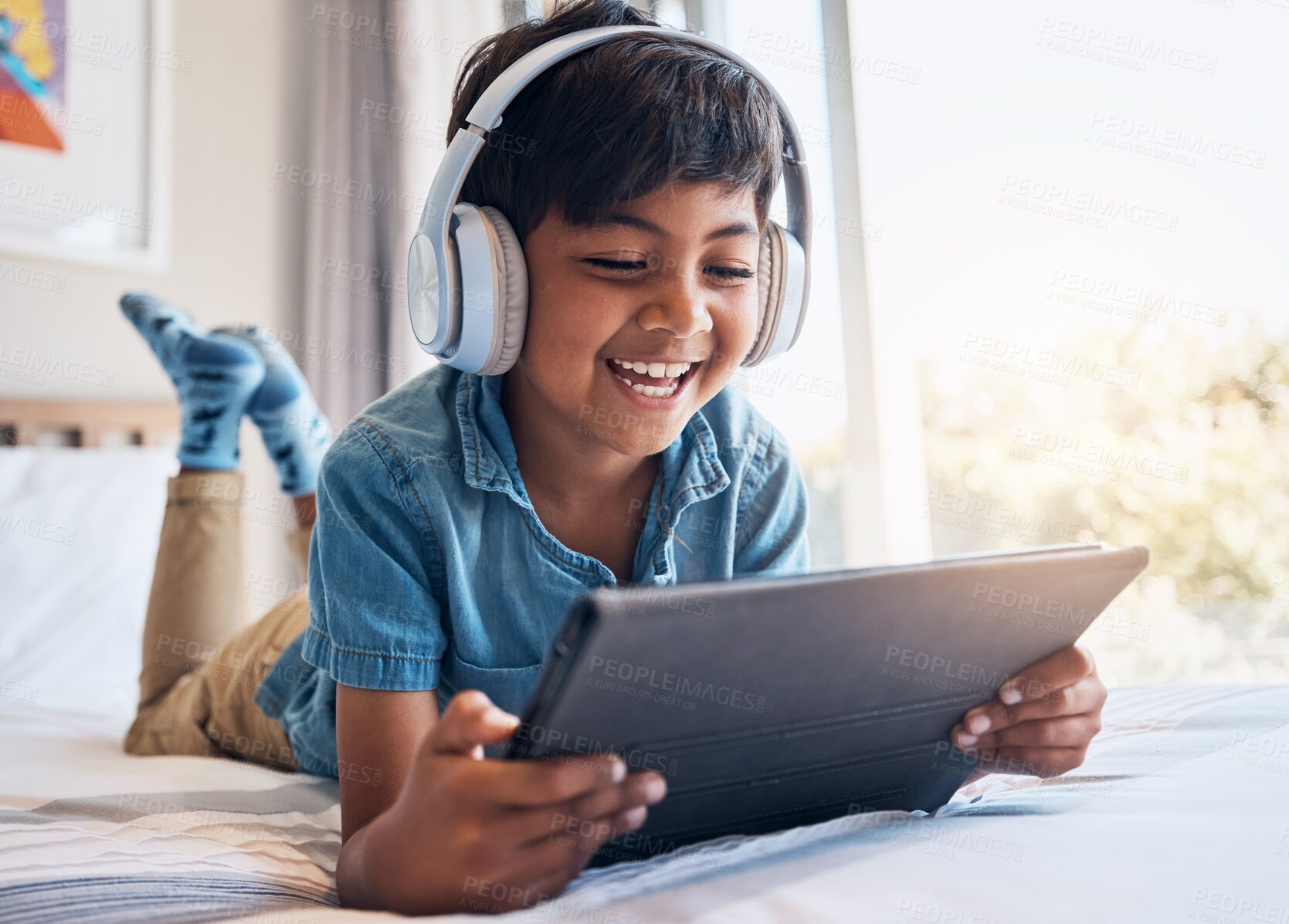 Buy stock photo Happy boy, tablet and headphones on bed, smile or relax for streaming subscription, movie or funny video. Male child, digital touchscreen and happy in bedroom with audio tech, show or cartoon in home