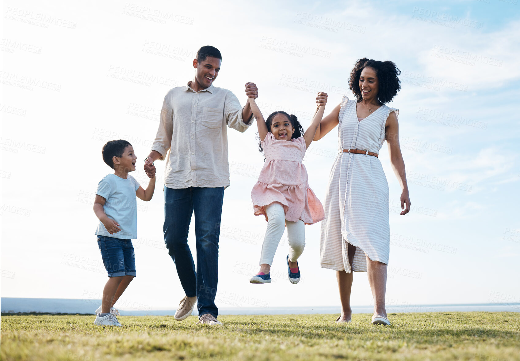 Buy stock photo Family, holding hands and outdoor at a park with love, care and happiness together in nature. Young man and woman or parents swing children on walk, travel and playing on fun journey or holiday