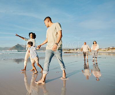 Buy stock photo Big family, holding hands and walking at the beach with conversation, relax and bond on blue sky background. Love, child and parent with grandparent at the ocean for travel, fun and freedom in Bali