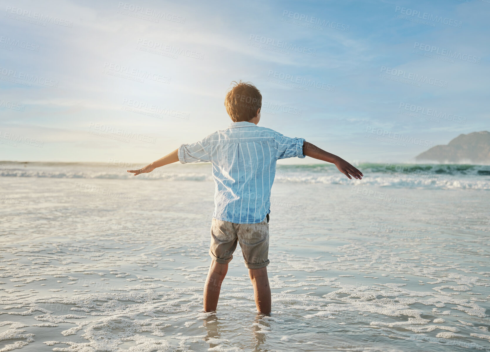 Buy stock photo Freedom, fun and child in waves at beach, playful on tropical summer holiday in Australia with blue sky. Ocean, adventure and sun, back of boy in water and playing with energy on island vacation