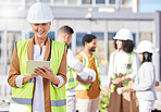 Tablet, architecture and a senior woman construction worker on a building site with her team in the city. Technology, planning and safety with a female engineer reading a blueprint on the internet