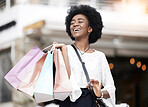 Shopping bag, happy customer and black woman walking outdoor in a city for retail deal, sale or promotion. African person with a smile or excited about buying fashion commerce product on urban travel
