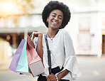 Black woman, shopping bag and portrait of a happy customer outdoor in a city for retail deal, sale or promotion. African person with a smile and excited about buying fashion product on urban travel