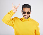 Man, sunglasses and horns sign in studio portrait, rock icon or hand gesture with clothes by white background. Young guy, model and devil fingers for attitude, fashion or crazy with emoji for culture