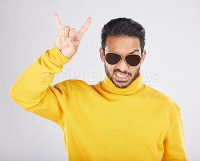 Buy stock photo Man, sunglasses and horns sign in studio portrait, rock icon or hand gesture with clothes by white background. Young guy, model and devil fingers for attitude, fashion or crazy with emoji for culture