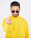 Man, middle finger and sunglasses in studio portrait with anger, rude and frustrated by white background. Indian fashion model, guy and emoji for sign language, vote or opinion with hand for conflict