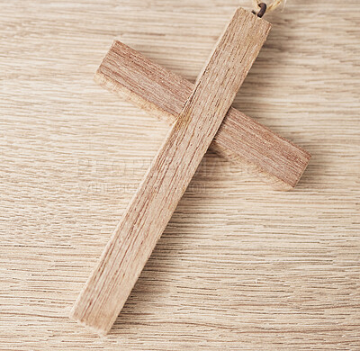 Background, religion and closeup of wooden cross on table for worship to God, prayer and resurrection of Jesus Christ. Faith, christianity and crucifix sign for holy spirit, heaven or spiritual trust