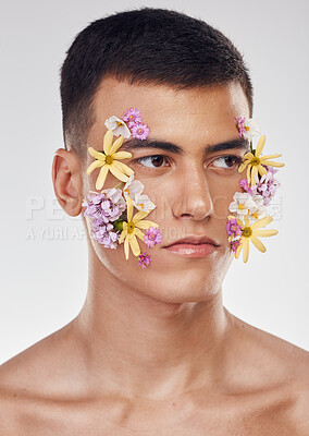 Buy stock photo Thinking, beauty and a man with flowers on a studio background for ecology or nature aesthetic. Creative, serious and a male model with plants for facial cosmetics, skincare or an idea on a backdrop