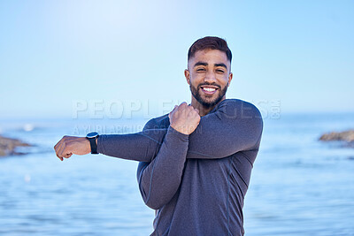 Buy stock photo Beach portrait, exercise and happy man stretching arm for outdoor freedom, sports workout or start routine. Blue sky, natural sea water and Indian person doing relax training warm up on nature island