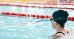 Woman, pool and swimming in water at start for sports fitness, race or training and practice. Active female person, athlete or professional swimmer getting ready for lap, workout or indoor exercise