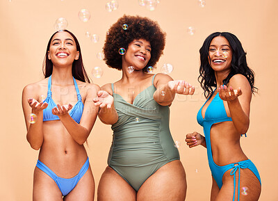 Buy stock photo Beauty, bubbles and body positive with model friends in swimwear on a beige background in studio. Smile, natural or plus size with a group of women posing for skincare, diversity and inclusion